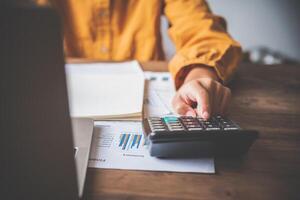 business person sitting at a desk at an office By using the calculator to work. Business Concept Analysis and Planning photo