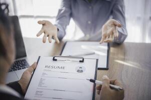 Human resource manager Is explaining the job to the job seeker before filling out a resume on the application form to consider accepting for employment in the company. photo