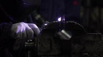 Iron welding with bright light and smoke at manufacturing. Clip. Industrial worker man at the factory welding close up by arc video