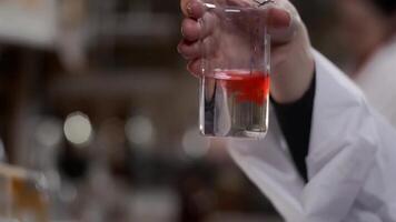 Young scientist works in modern biological lab. A researcher in a lab coat studying a piece of equipment for an experiment. The microelectronics video