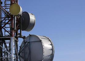 telecomunicación antena con múltiple satélite platos en contra el azul cielo foto