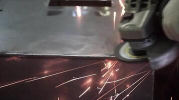 Metall Polieren mit ein Hand Schleifer mit ein Polieren Scheibe. Clip. Fabrik Arbeiter beim Werkstatt Mahlen Stahl Stange mit Schleifmittel Rabatt und fliegend Funken. Hand Schleifer Arbeitsablauf Schaffung rostfrei Rohr video