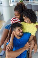 Positive cheerful multi-ethnic family wife husband child sitting together on couch at home. Close up focus on little daughter and beautiful mother. Happy multiracial family concep photo