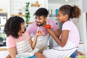 familia con adorable hijas reunido en moderno cocina Cocinando juntos.disfrutar comunicación y cocina pasatiempo concepto. foto