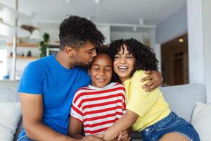 familia sentado en sofá sonriente a cámara en moderno Departamento antecedentes contento familia con hija jugando a hogar y fin de semana para familia foto