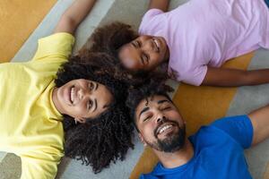 grupo retrato de un familia acostado en piso a hogar foto