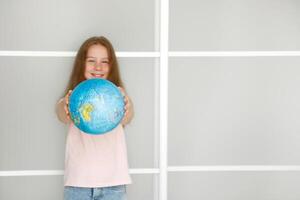 girl holds out a globe, face blurred photo