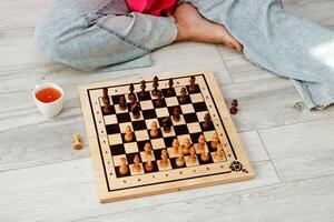 chessboard with poison pieces with a woman sitting on the floor photo