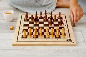 woman playing chess at home sitting on the floor photo