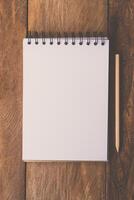 blank notebook with pencil on wooden table photo