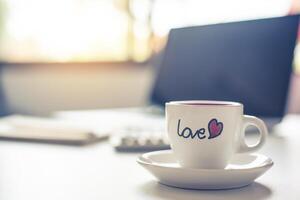 café taza con amor es metido en el escritorio. foto