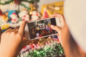 niña manos participación Navidad árbol hermosamente decorado teléfono. foto