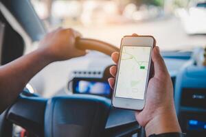 conductor sentado en el coche y participación móvil inteligente teléfono con mapa GPS navegación solicitud foto