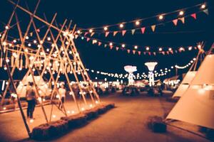 Blurred images of the background party in the festive festivities during the night, consisting of people and glittering bokeh. photo