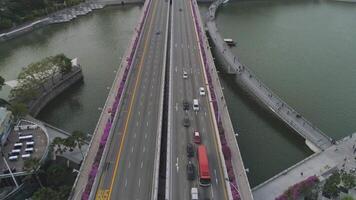 Singapore - 25 September 2018. Aerial for Singapore with many cars on the bridge above the lake and city buildings background. Shot. Singapore city skyline with bridge and modern buildings. video