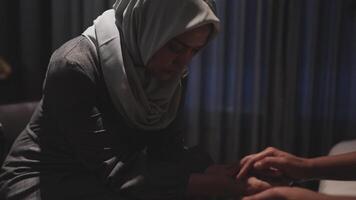 Close-up of two young female friends holding hands in support of their friend's video