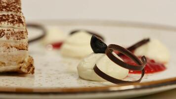 delizioso cheesecake con fragola e bacca salsa. mousse torta con fresco fragole, torta di formaggio e fragole su superiore. pezzo di torta con un' fetta di fragola a il superiore di un' piatto video