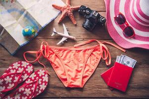 belleza naranja bikini y accesorios en de madera piso para viaje en verano foto