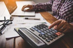 Businessman are working with a calculator and document. Meeting report in progress. in office business concept photo