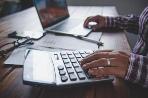 Businessman are working with a calculator and document. Meeting report in progress. in office business concept photo