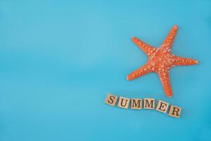 top view Simulated starfish and word SUMMER placed on a blue background concept summer travel photo