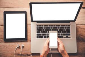 topview businessmen use smartphones and laptop to connect and find information in office photo