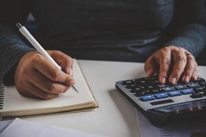 Businessman are working with a calculator and document. Meeting report in progress. in office business concept photo