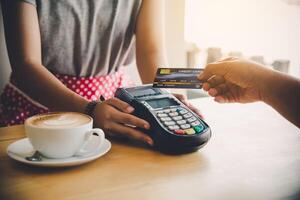 Close up of hand using credit card to pay by sending the credit card to the staff at the credit card swipe machine. Online payment photo