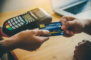 Close up of hand using credit card to pay by sending the credit card to the staff at the credit card swipe machine. Online payment photo