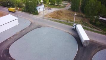 Aerial view of trucks parked in front of industry building. Clip. Aerial. Aerial Top View of White Semi Truck with Cargo Trailer Parking with Other Trucks on Special Parking Lot. Aerial view of two video