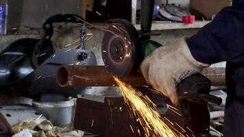 Arbeiter mit Winkel Schleifer im Fabrik und werfen Funken. rahmen. Mann tragen schützend Uniform und Schneiden Metall mit Winkel Schleifer. video