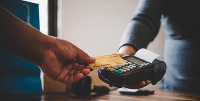 Close up of hand using credit card to pay by sending the credit card to the staff at the credit card swipe machine. Online payment photo