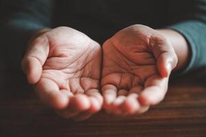 open two hands on wood background - concept help photo