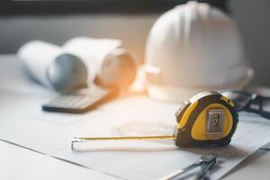 tape measure is placed on the work table with a house plan designed Including engineering equipment photo