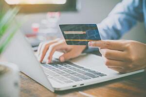 Woman holding credit cards and mobile phones are now shopping over the internet by paying by credit card. photo