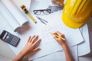 ingeniero trabajando en oficina con planos, inspección en lugar de trabajo para arquitectónico plan, construcción proyecto ,negocio construcción foto