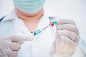 Doctor with syringe ready for injection of vaccine to patient. Vaccination concept. photo