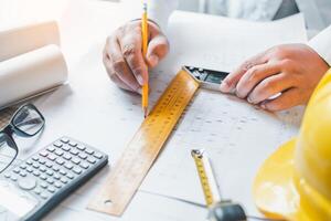 ingeniero trabajando en oficina con planos, inspección en lugar de trabajo para arquitectónico plan, construcción proyecto ,negocio construcción foto