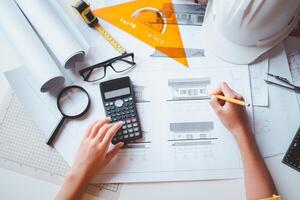 ingeniero trabajando en oficina con planos, inspección en lugar de trabajo para arquitectónico plan, construcción proyecto ,negocio construcción foto