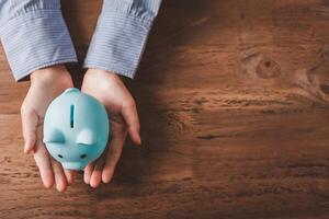 hand holding piggy bank, saving money and finance accounting concepts photo