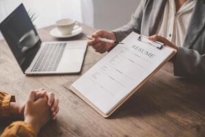 Human resource manager Is explaining the job to the job seeker before filling out a resume on the application form to consider accepting for employment in the company. photo