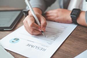 People are filling out their resume on the job application form to apply for a job at a company. photo