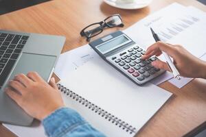 The accountant's hand is using the calculator. For cost analysis Profit and loss and tax calculation concept preparation of financial statements photo