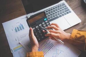 business person sitting at a desk at an office By using the calculator to work. Business Concept Analysis and Planning photo