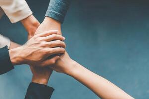 Top view hands of business people come together in a stack of hands to symbolize collaboration, teamwork to achieve goals and success. photo