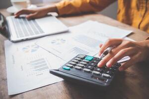 business person sitting at a desk at an office By using the calculator to work. Business Concept Analysis and Planning photo