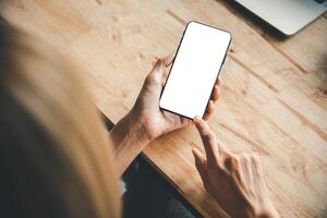 asiático negocio mujer mano utilizando y conmovedor inteligente teléfono con blanco blanco vacío pantalla. foto