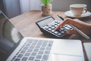 business person sitting at a desk at an office By using the calculator to work. Business Concept Analysis and Planning photo