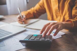 business person sitting at a desk at an office By using the calculator to work. Business Concept Analysis and Planning photo