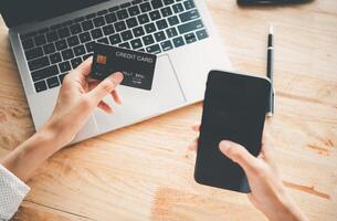 manos de mujeres con una tarjeta de crédito y trabajo en el pago en línea de una computadora portátil para compras en línea foto